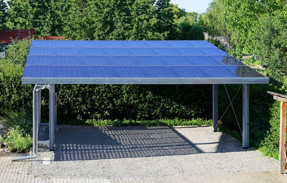 Carport r&eacute;sidentiel ext&eacute;rieur avec toiture &eacute;quip&eacute;e de panneaux solaires photovolta&iuml;ques bleus