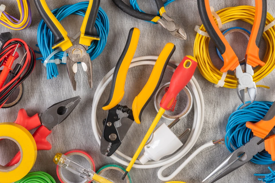 Atelier d'électricien avec outils professionnels disposés sur établi en bois