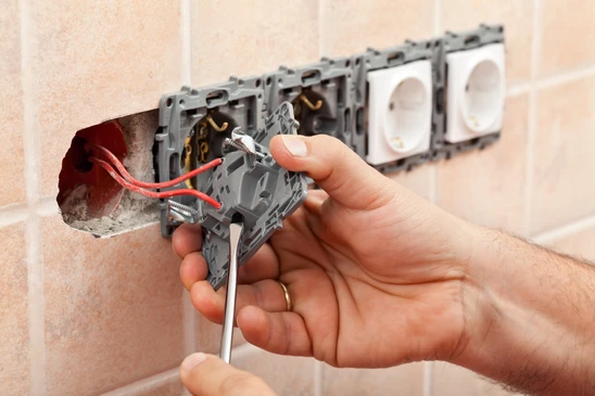 Intérieur résidentiel, mains d'électricien installant des prises électriques murales