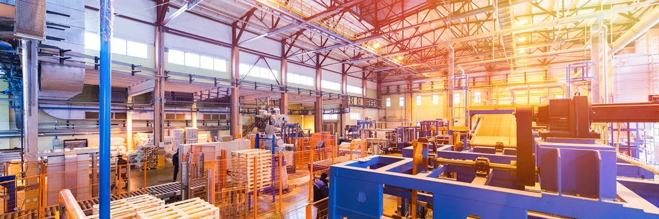 Intérieur d'usine industrielle moderne avec ouvriers opérant des machines de production automatisées