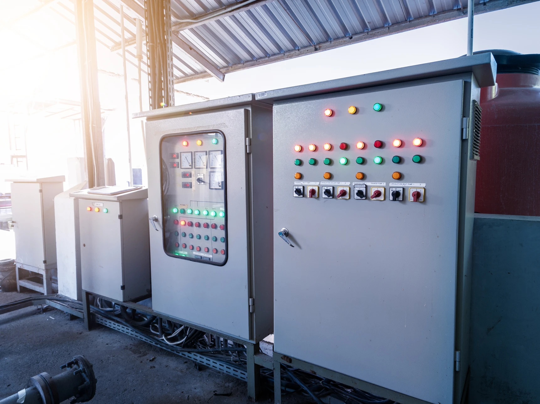 Technicien électricien travaillant dans armoire électrique industrielle, utilisant pince coupante pour maintenance installation