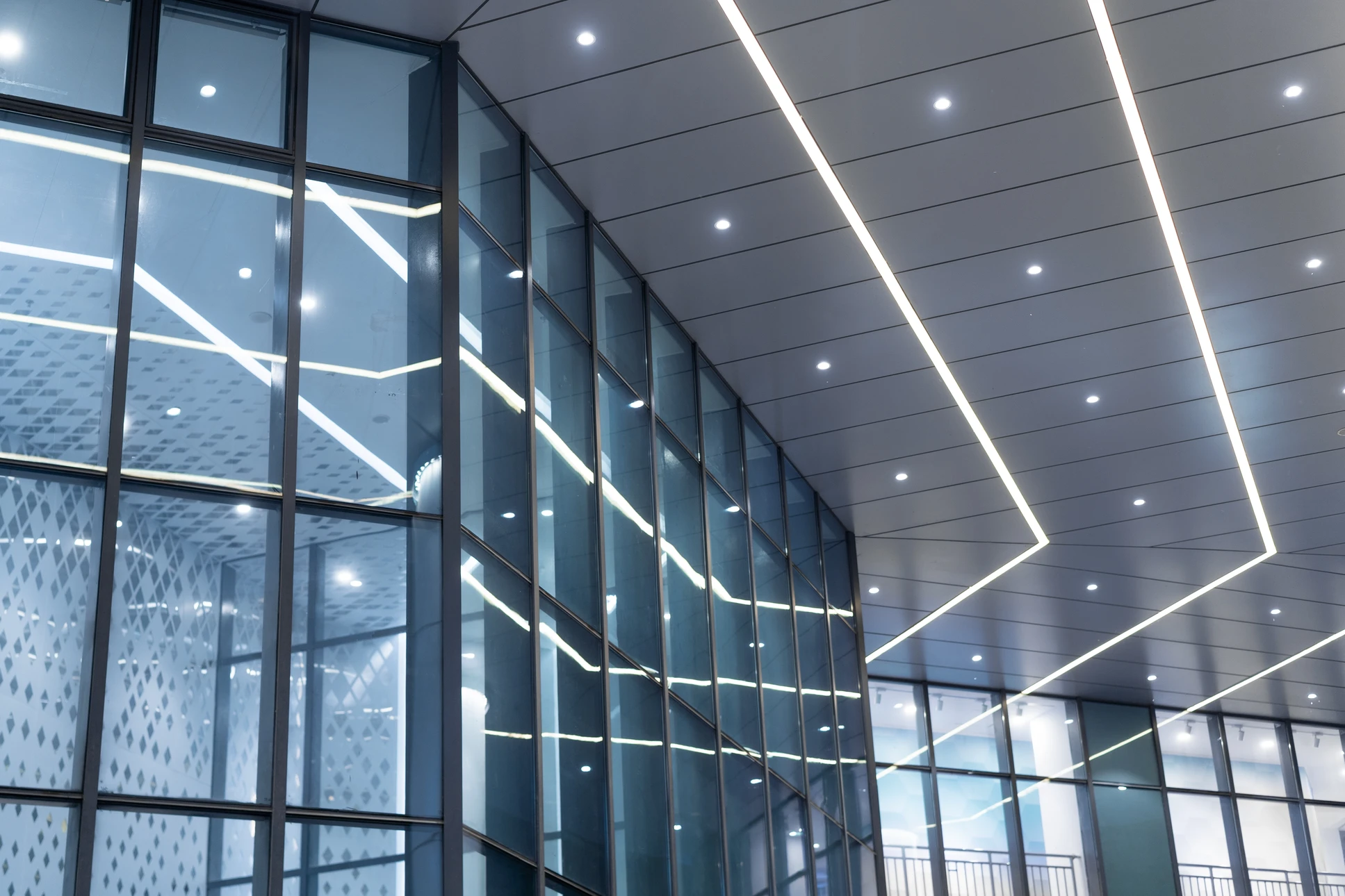 Électricien professionnel en tenue de travail effectuant l'installation ou la maintenance d'éclairage LED moderne dans un atelier ou espace de travail professionnel. L'image doit montrer clairement les luminaires LED en cours d'installation ou déjà installés, dans un environnement de travail réaliste (usine, atelier, entrepôt), avec un professionnel concentré sur sa tâche.
