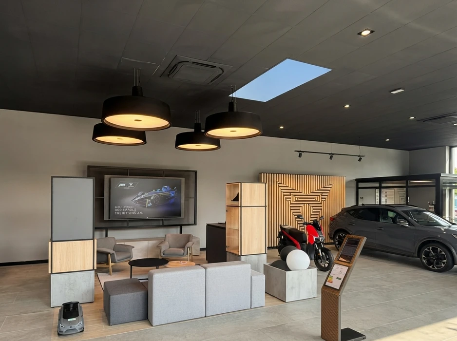 Photographie d'un environnement professionnel ou industriel (atelier, entrepôt ou bureau) montrant des installations d'éclairage fonctionnelles et modernes en plein fonctionnement. L'éclairage doit être clairement visible, bien distribué et adapté à un usage professionnel. On peut voir des panneaux LED de plafond ou des projecteurs orientés illuminant efficacement l'espace de travail, transmettant une image de qualité, de fiabilité et de maîtrise technique en éclairage tertiaire et industriel.