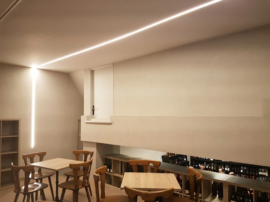 Intérieur de bureau moderne avec plafond suspendu noir intégrant un éclairage LED linéaire blanc continu